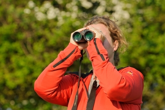 Young woman birdwatching at Rutland Water