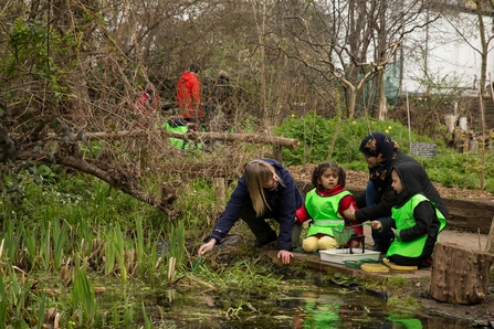 A nursery group peer into a pond on a visit to the centre for wildlife gardening in London