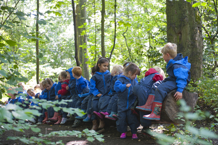 Small children in a wood wearing blue overalls