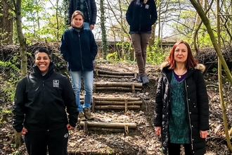 5 Natural Prospect trainees standing on woodland steps