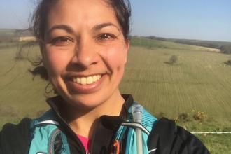 Daisy smiling at the camera with rolling hills in the background