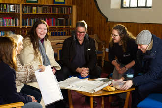 A group of people sit around a table, smiling and chatting