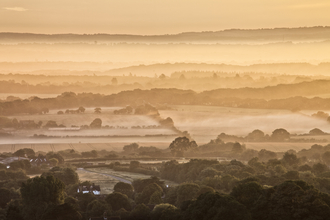 Misty sunrise across country landscape