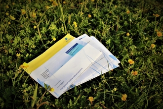 Insurance papers placed on grass. 