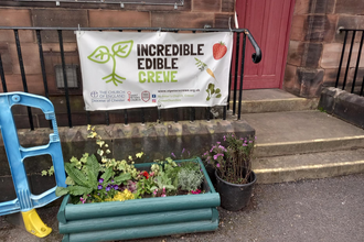 A sign outside a building reading 'Incredible Edible Crewe'