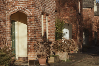 Cottage lined with plant pots. 