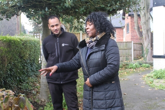 Two people in conversation outside a house