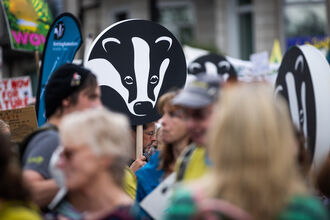 A Wildlife Trusts banner is carried in a crowd of people