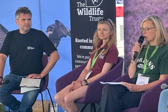 Wildlife Trust Chief Executive Craig Bennett and two female panellists on the stage at Groundswell having a discussion