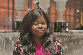 Nanret Senok sat at a table, smiling at the camera