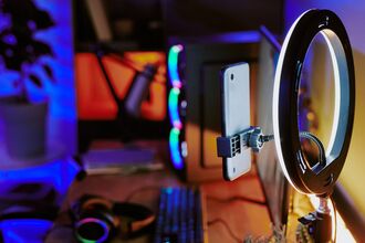 Modern Gaming Setup with Smartphone Ring Light and Streaming Equipment at Home by annastills