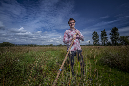 Young volunteer stands in grassland