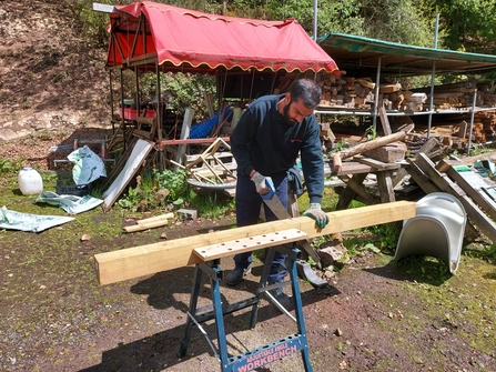 Ali Rajabali sawing a piece of wood