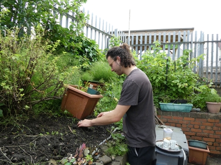 Student works on a planting bed in a community garden. 