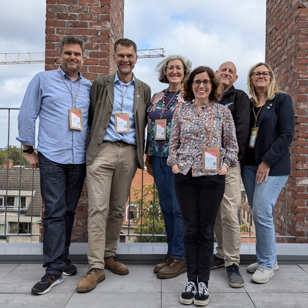 Six members of The Wildlife Trusts team at an IUCN Europe Forum Meeting. They are stood in a group, outside, smiling together at the camera. Leigh Morris is one of the members of the group