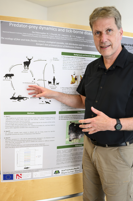 Marco Heurich standing by an infographic
