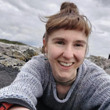George Short Smiling lying on a rocky beach