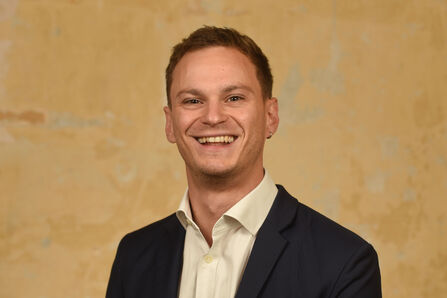 A headshot of Charlie Dixon, smiling at the camera