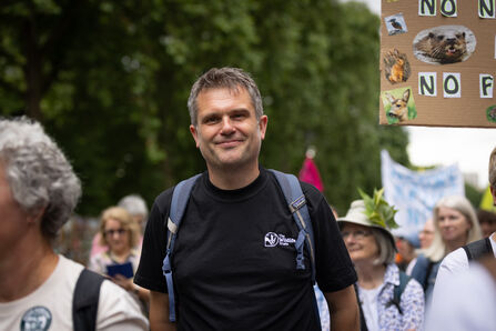Wildlife Trusts CEO Craig Bennett in black t-shirt with logo surrounded by people on a march through London streets