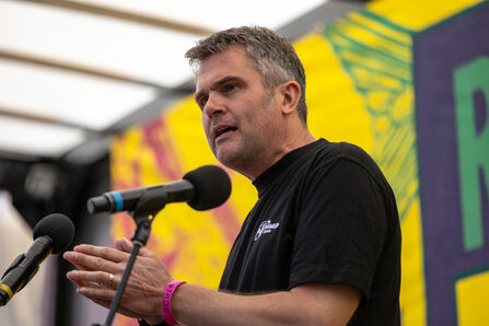 Craig Bennett stood speaking into microphones on a stage at the Restore Nature Now march