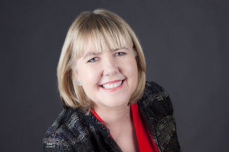 A headshot of Gillian, smiling broadly at the camera