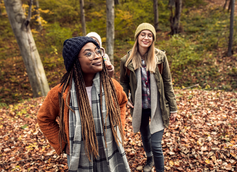 Three women walking in a woodland.