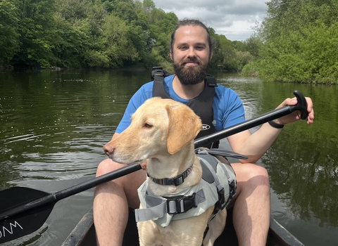 Arran Wilson and his dog in a canoe