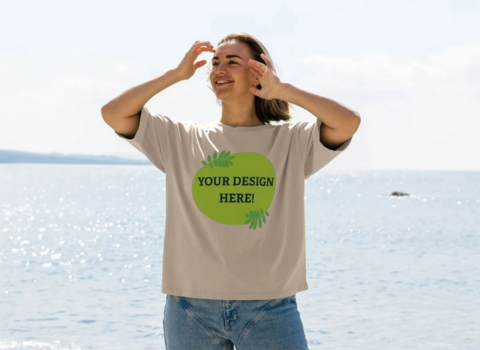 Woman standing on a beach wearing a t-shirt that reads "your design here"