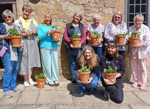 a group of people holding flowerpots