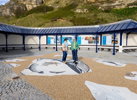 Two people outside with a mosaic